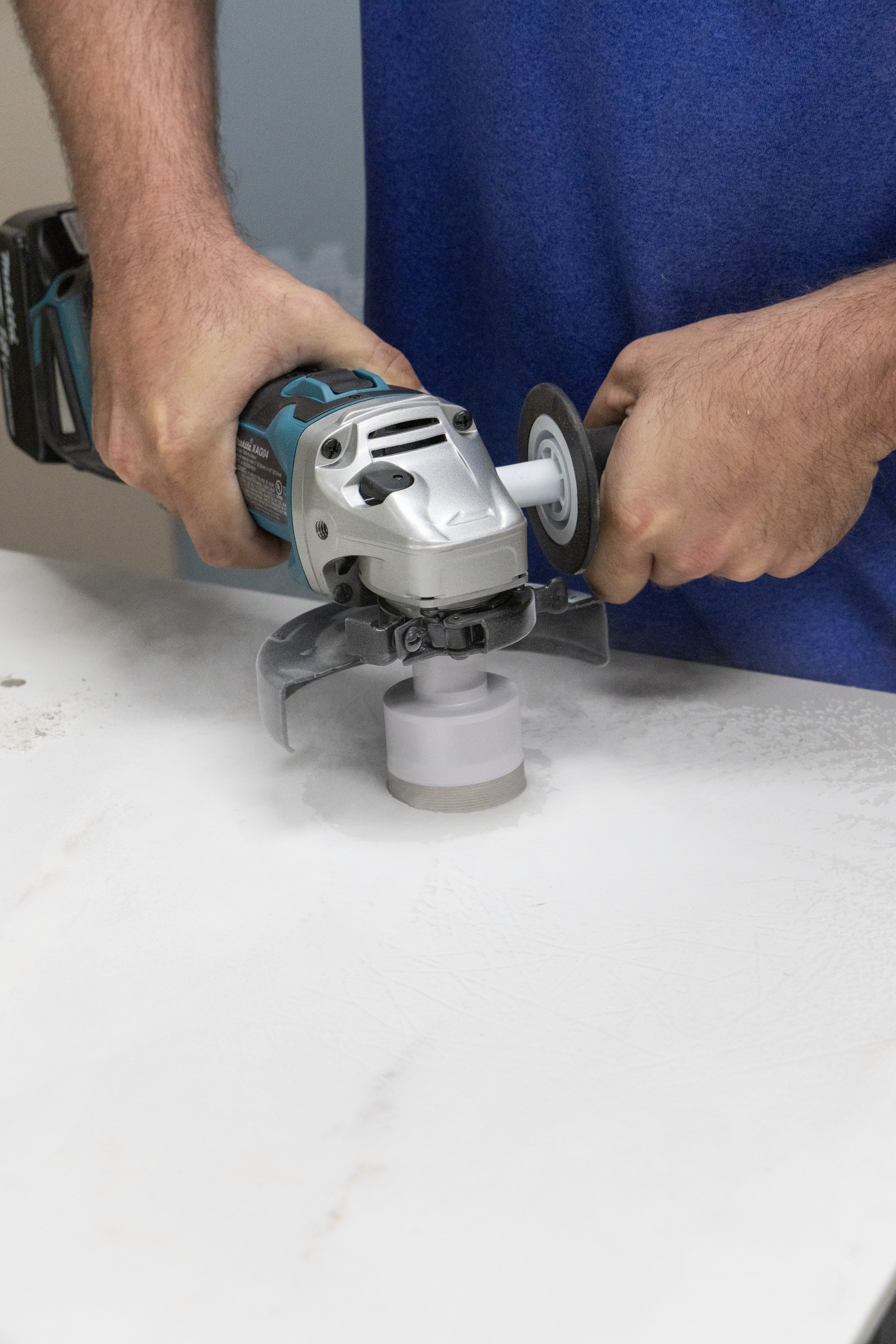 man using an angle grinder with a diamond hole saw